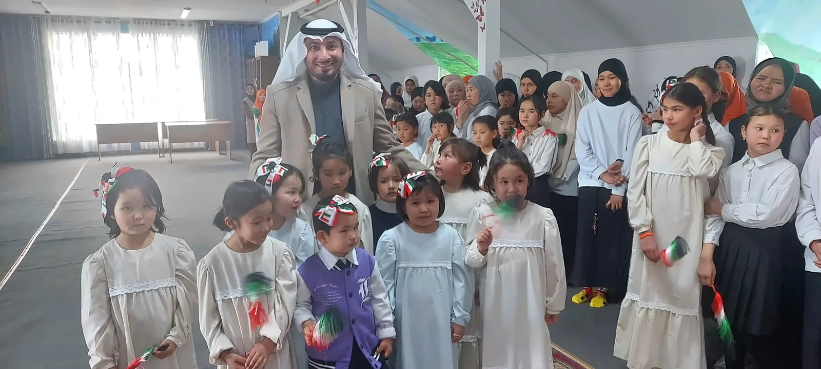 A group photograph with children and adults in a decorated hall